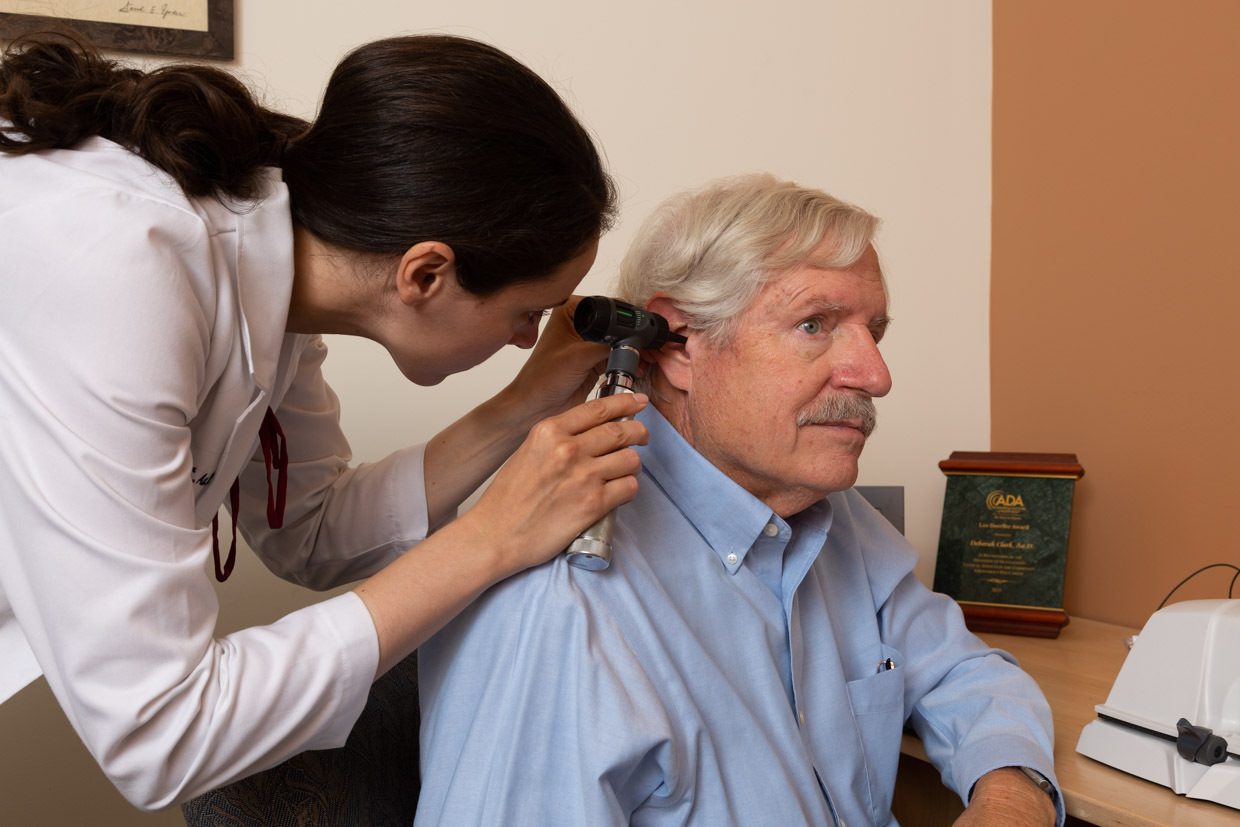 A female audiologist performing otoscopic inspection